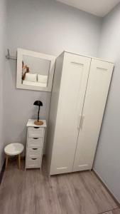 a room with a white cabinet and a desk with a lamp at European District Hostel in Brussels