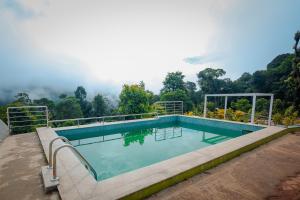 a swimming pool with a view of the mountains at The Breeze Cottage in Kalasa