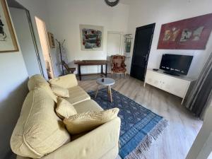 a living room with a white couch and a tv at Atypical architect-designed house in Vence