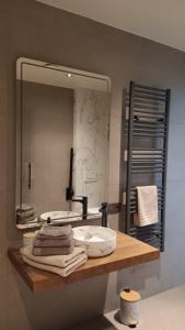 a bathroom with a mirror and a counter with towels at Huis Leon in Houthulst +18 photos
