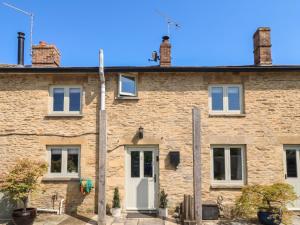 an old brick house with a white door at 2 The Gardens in Lechlade