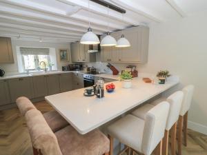 a kitchen with a large white table and chairs at 2 The Gardens in Lechlade