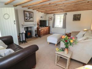 a living room with a couch and a table with flowers at 2 The Gardens in Lechlade
