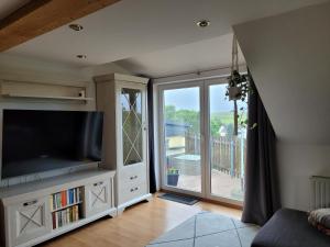 a living room with a large television and a balcony at Bella Vista in Burgstaedt