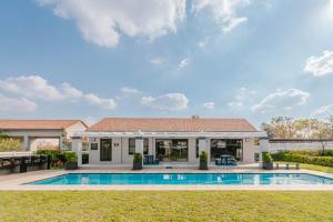 a home with a swimming pool and a house at Royalty Suites in Chartwell Sandton in Chartwell