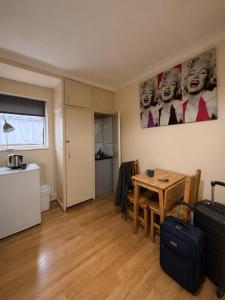 a living room with a table and a kitchen at 24/7 London Hostel in London