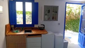 a kitchen with a sink and a blue window at El Portal, 12 mins from Sitges in Olivella
