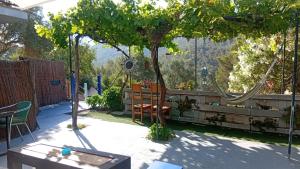 a patio with a tree and a swing at El Portal, 12 mins from Sitges in Olivella