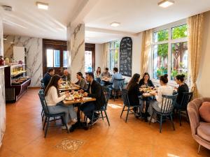 a group of people sitting at tables in a restaurant at Anadolu Hotel in Istanbul