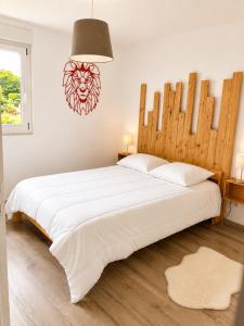 a bedroom with a large white bed and a lamp at Appart Vosges in Fresse-sur-Moselle