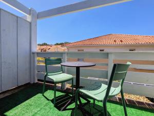 a patio with two chairs and a table on a balcony at Résidence Au Pitot, Biscarrosse-Plage in Biscarrosse-Plage