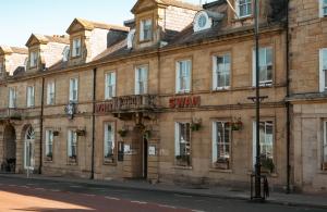 a building with a sign on the front of it at White Swan Hotel in Alnwick
