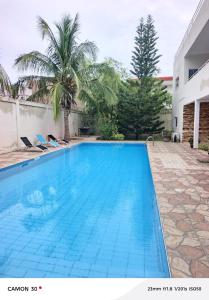 a swimming pool in a villa with palm trees at or bleu in Lomé