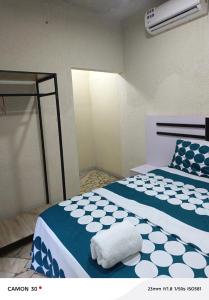 a bedroom with two beds with blue and white sheets at or bleu in Lomé +15 photos