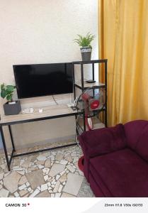 a living room with a tv and a couch at or bleu in Lomé
