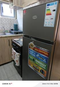 a refrigerator in a kitchen with many stickers on it at or bleu in Lomé