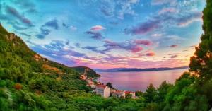 a view of a town on a hill next to a body of water at Borovik Guest House in Živogošće