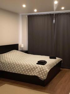a bedroom with a bed with a black and white comforter at Dzīvoklis Baldone, Latvija in Baldone +32 photos