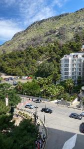a parking lot with a building and a mountain at Ayzal Apartment in Shëngjin