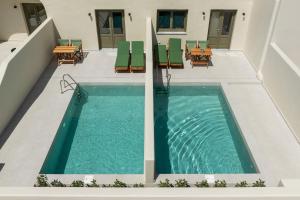 an infinity pool with chairs and tables on a patio at Kaminia Holiday Homes in Éxo Goniá