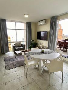 a living room with a white table and chairs at Oceanic Apartment - Ocean views - Self-Catering in Durban