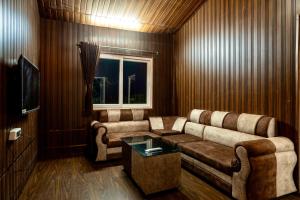 a living room with a couch and a television at 11 Haven Street Kodaikanal in Kodaikānāl