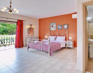 a bedroom with a bed and orange walls at Villa Alexandros in Spartià +51 photos