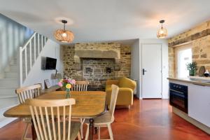 a kitchen and dining room with a table and chairs at Maison bretonne de charme in Plumergat