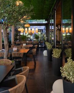 a restaurant with tables and chairs and potted plants at Hotel Rubis in Ferizaj