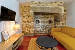 a living room with a couch and a table at Maison bretonne de charme in Plumergat