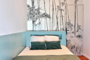 a bedroom with a bed with a wall with trees at Maison bretonne de charme in Plumergat