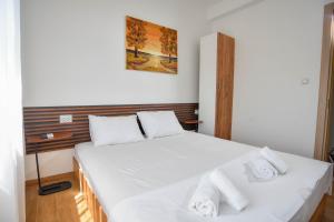 a bedroom with a bed with white sheets and towels at Villa Mladost Luxury in Veles +35 photos