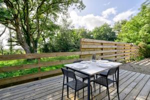 a table and chairs on a wooden deck at Maison bretonne de charme in Plumergat