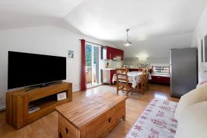a living room with a flat screen tv and a table at Appartement Aime La Plagne in Aime-La Plagne