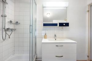 a white bathroom with a sink and a shower at Appartement Aime La Plagne in Aime-La Plagne +18 photos