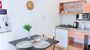 a small kitchen with a table and a microwave at G8 Hermoso Monoambiente con Cochera 2 huéspedes in Villa Ángela