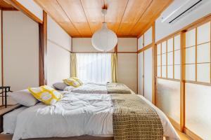 a bedroom with two beds and a large window at AO Niigata in Niigata