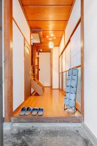 a hallway with two pairs of shoes and a chair at AO Niigata in Niigata +17 photos