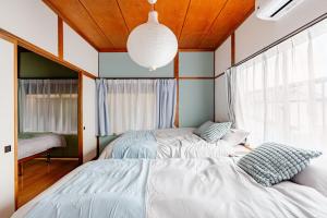 a bedroom with two beds and a large window at AO Niigata in Niigata