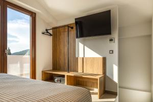 ein Schlafzimmer mit Bett und Flachbildfernseher in der Unterkunft Sunstar Suites in Syvota