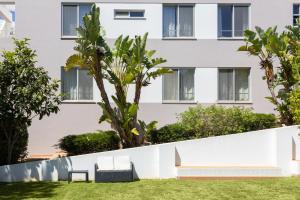 a white wall with a bench in front of a building at Marachique Villa - Torralvor in Alvor