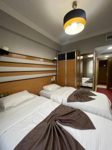 a hotel room with two beds and a light at Quars Garden Hotel in Koçyazı