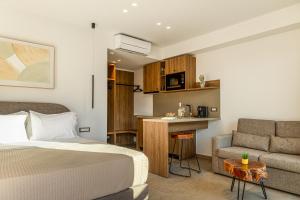 ein Schlafzimmer mit Bett und Sofa und eine Küche in der Unterkunft Sunstar Suites in Syvota