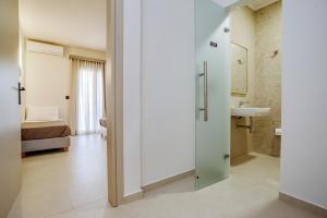 a room with a bathroom with a sink and a bed at Seaside Resorts in Kavos