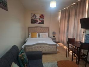 a bedroom with a bed and a couch at Executive Express Rooftop Pool suites- Ngara in Nairobi