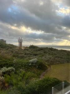 a view of the ocean and a tower on a hill at Strandvilla Zeegloed in Sint-Idesbald