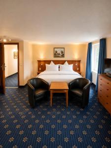 a hotel room with a bed and two chairs at Hotel zum Felsenkeller Oybin in Oybin