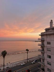 a view of a building and the beach at sunset at Frente al mar in Montevideo