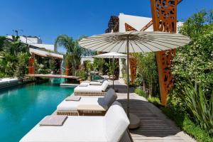 an outdoor pool with lounge chairs and an umbrella at Mohala Boutique Hotel in Diso