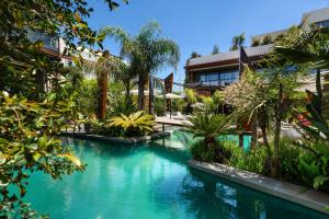 a swimming pool in front of a house with trees at Mohala Boutique Hotel in Diso